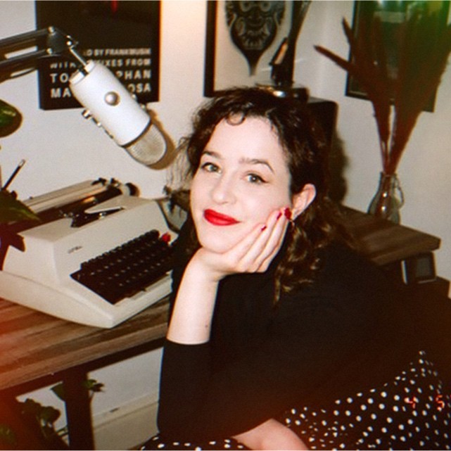 Rachel C-P, copywriter at The Pitch, smiling at the camera with a typewriter on her desk